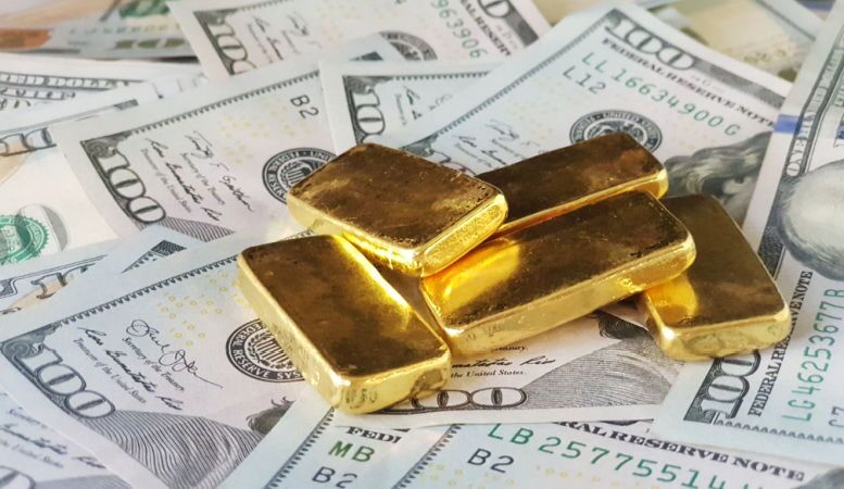 gold bars with one hundred dollar bills
