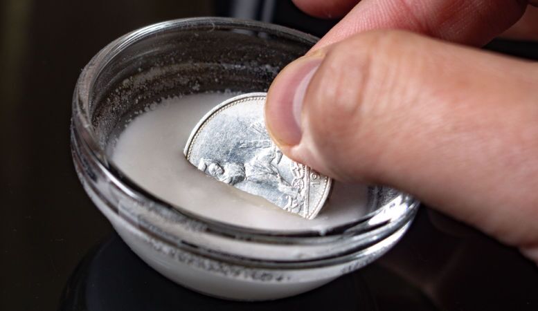man using silver polish for cleaning silver coins