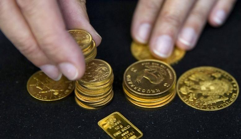 dealer arranging gold coins and gold bar