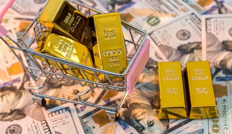 gold bars lie in shopping cart with us dollar banknotes