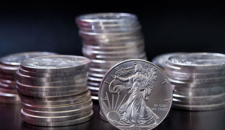 one ounce silver eagle coin in front o stacks of silver eagle coins