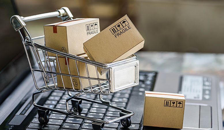 shopping cart with paper boxes on laptop