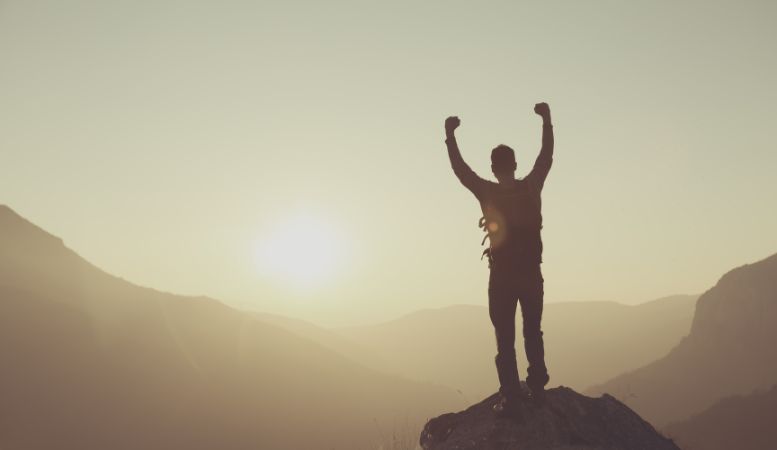 man celebrating success in the mountains