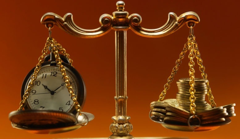 coin and clock in opposite sides of a weighing scale