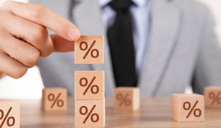 businessman stacking wooden cubes with percentage sign