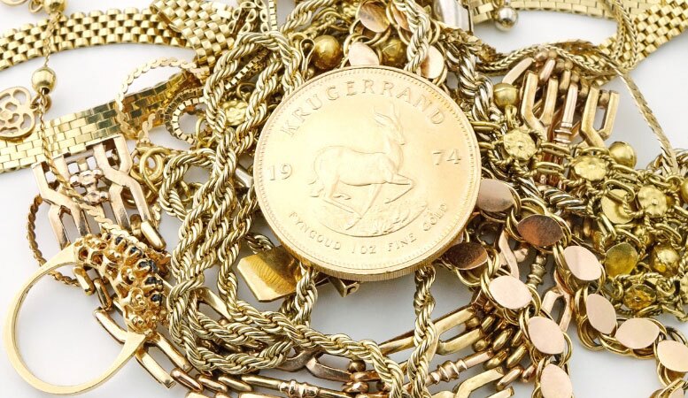 one ounce gold coin and pile of gold jewelries