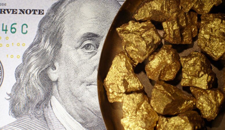pile of gold nuggets on dollar banknotes