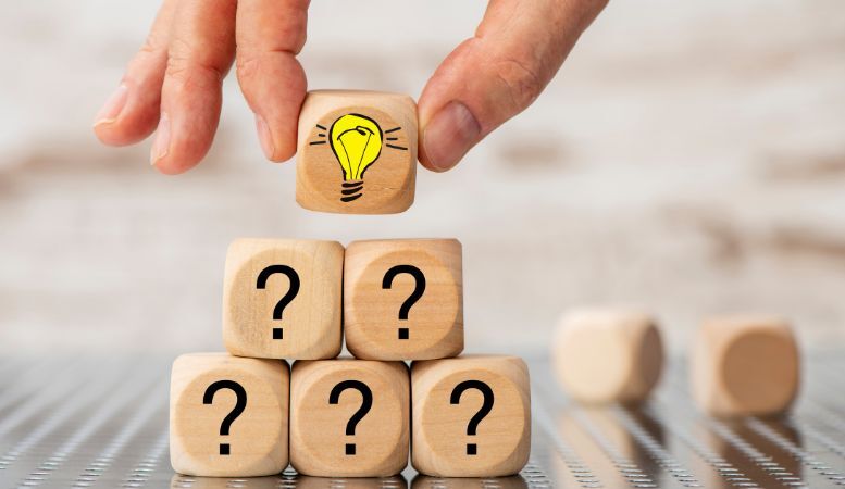 man stacking wooden cubes with question mark and lightbulb icon
