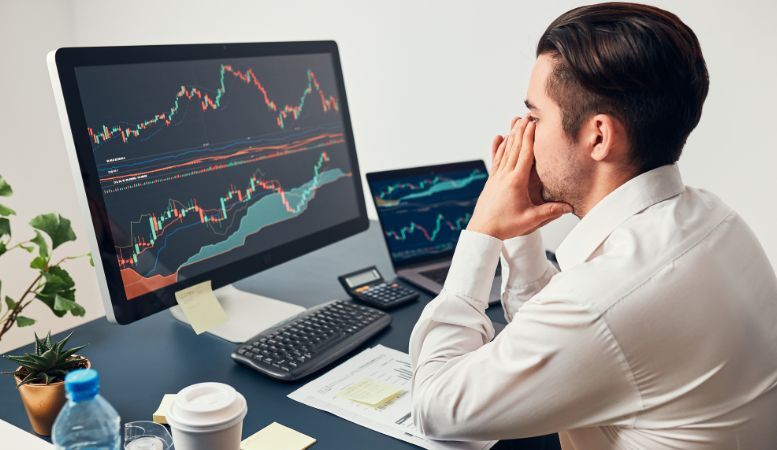 worried businessman looking at price charts