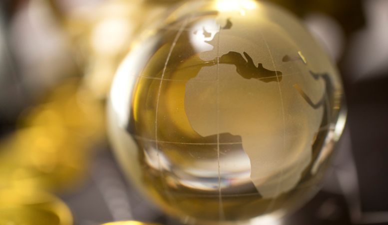 golden globe with blurred gold coins on background