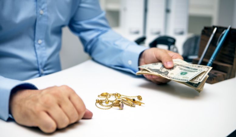 man paying cash when buying gold jewelries at jewelry shop
