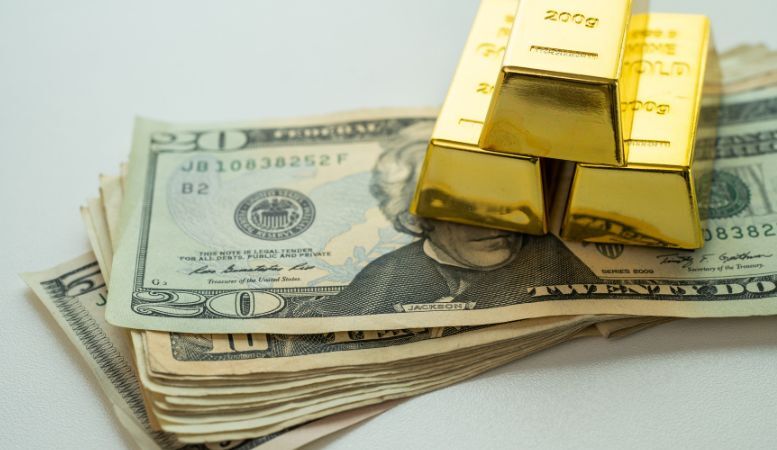 dollar banknote with gold bars on top