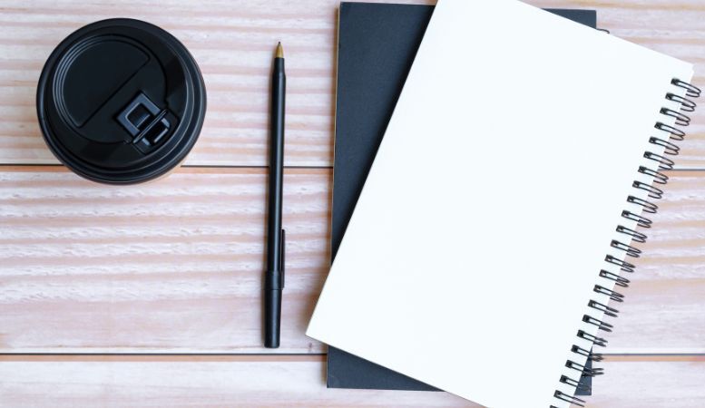 notepad pen coffee cup on table